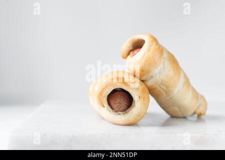 Rotolo di salsiccia su un vassoio di marmo, rotolo di salsiccia intrecciato su un vassoio di marmo, maiali grandi in uno spuntino coperta Foto Stock