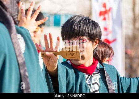 Primo piano, giovane giapponese Yosakoi ballerino e tenendo naruko, clapper, al festival Kyusyu Gassai a Kumamoto. Focus sul naruko. Foto Stock