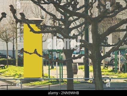 Colonna pubblicitaria vuota in un luogo cittadino con spazio copia gratuito giallo, mock promozione in su. Pannello pubblicitario vuoto Foto Stock