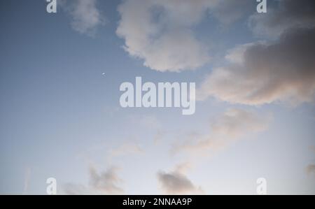luna di mezzaluna nel cielo serale da nuvole luce soffusa durante l'alba Foto Stock