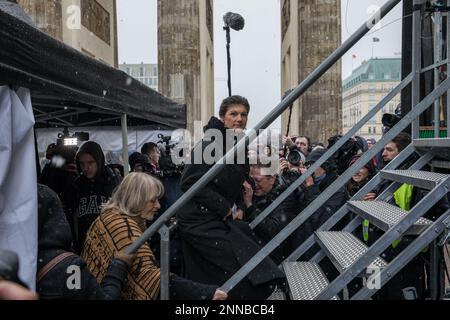 Berlino, Germania. 25th Feb, 2023. Migliaia di persone si sono riunite sabato 25 febbraio 2023 alla porta di Brandeburgo a Berlino per protestare contro la consegna di armi in Ucraina. Il raduno ''Aufstand fÃ¼r den Frieden'' (rivolta per la pace) fu chiamato dal politico Sahra Wagenknecht e dal femminista Alice Schwarzer. La polizia ha stimato che circa 13.000 persone hanno partecipato all'evento, mentre Wagenknecht ha sostenuto che 50.000 erano presenti. I partecipanti hanno chiesto negoziati di pace con la Russia e la sospensione delle forniture di armi all'Ucraina. L'evento è iniziato con discorsi dell'attrice Corinna Kirchhof Foto Stock