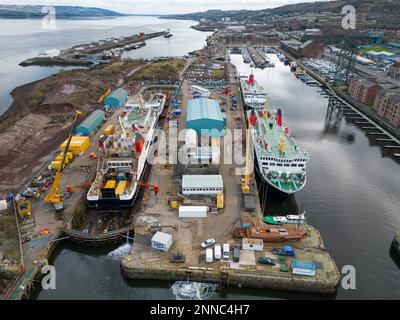 Greenock, Scozia, Regno Unito. 25 febbraio 2023. Il traghetto Glen Sannox è visto nel molo a secco a Greenock, dove è in fase di montaggio. Altri tre traghetti Caledonian Macbrayne sono anche adiacenti in fase di riparazione e manutenzione, l'isola di Lewis, le isole Caledonian e il MV Loch Fyne. Questi traghetti sono attualmente fuori servizio per Calmac. Iain Masterton/Alamy Live News Foto Stock