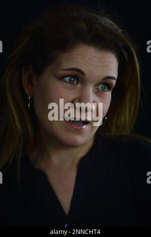 ritratto di una bella donna bionda che allarga gli occhi e guarda scetticamente al lato Foto Stock