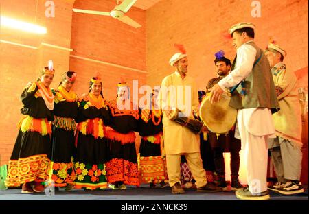 Le donne della tribù Kalash indossano abiti tradizionali partecipano al Chilam Joshi Celebration Festival in occasione dell'arrivo della stagione primaverile al Basant Hall di Hyderabad sabato 25 febbraio 2023. Foto Stock