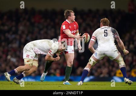 Nick Tompkins (al centro) del Galles scarica la palla mentre viene affrontato dal Jack Van Poortvliet (a sinistra) dell'Inghilterra durante la partita delle sei Nazioni della Guinness al Principato Stadium di Cardiff. Data immagine: Sabato 25 febbraio 2023. Foto Stock