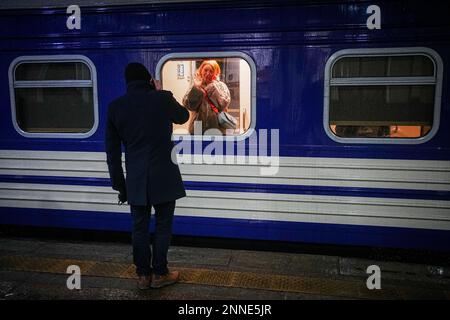 Kiew, Ucraina. 25th Feb, 2023. Una coppia dice Arrivederci alla stazione ferroviaria principale di Kiev. Da qui, il treno notturno parte per la città di confine polacca di Przemysl. Gli uomini possono lasciare il paese solo su base molto limitata a causa della guerra. Credit: Kay Nietfeld/dpa/Alamy Live News Foto Stock