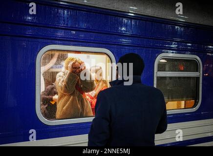 Kiew, Ucraina. 25th Feb, 2023. Una coppia dice Arrivederci alla stazione ferroviaria principale di Kiev. Da qui, il treno notturno parte per la città di confine polacca di Przemysl. Gli uomini possono lasciare il paese solo su base molto limitata a causa della guerra. Credit: Kay Nietfeld/dpa/Alamy Live News Foto Stock