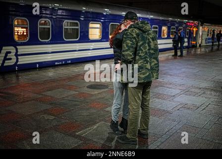 Kiew, Ucraina. 25th Feb, 2023. Una coppia dice Arrivederci alla stazione ferroviaria principale di Kiev. Da qui, il treno notturno parte per la città di confine polacca di Przemysl. Gli uomini possono lasciare il paese solo su base molto limitata a causa della guerra. Credit: Kay Nietfeld/dpa/Alamy Live News Foto Stock