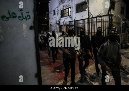 Jenin, territori palestinesi. 25th Feb, 2023. I militanti palestinesi pattugliano le strade durante una conferenza stampa organizzata da diversi gruppi militari nel campo profughi di Jenin in Cisgiordania, rifiutando il vertice di Aqaba. Il vertice si terrà domani, domenica, tra l'autorità palestinese, la Giordania, l'America e Israele nella città portuale giordana di Aqaba. Credit: Ayman Nobani/dpa/Alamy Live News Foto Stock