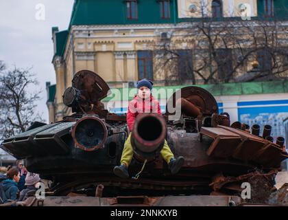 Kiev, Ucraina. 25th Feb, 2023. Con un atteggiamento disfiero, un bambino siede sul canone di un carro armato distrutto dalle forze armate ucraine a Kiev. Dopo un anno di guerra, la situazione rimane incerta. Città come Kyiv stanno riconquistando un'apparente normalità della vita quotidiana. (Credit Image: © Mario Coll/SOPA Images via ZUMA Press Wire) SOLO PER USO EDITORIALE! Non per USO commerciale! Foto Stock