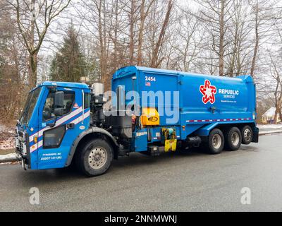 Republic Services Garbage Truck raccogliere i rifiuti e riciclare i bidoni della polvere nella comunità suburbana in Massachusetts, ma, USA. Foto Stock