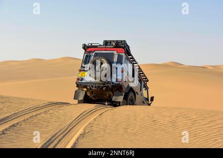 Il veicolo procede in discesa tra le dune di Sandwich Harbour, Namib-Naukluft-Park, Namibia Foto Stock