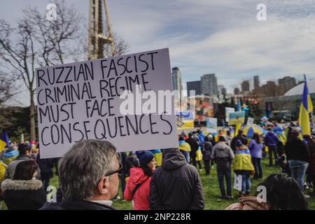 Seattle, Stati Uniti. 25th Feb, 2023. Un manifestante ha un cartello che dice "il regime criminale fascista russo deve affrontare delle conseguenze” con le bandiere ucraine mostrate in modo preminente. I manifestanti della democrazia si sono riuniti al Seattle Center per celebrare il primo anniversario dell'invasione russa dell'Ucraina. L’evento, organizzato dai gruppi locali ucraino-americani, ha attirato partecipanti provenienti da tutta la regione che si sono riuniti per chiedere la fine dell’aggressione russa e il ritorno al governo democratico in Ucraina. Credit: SOPA Images Limited/Alamy Live News Foto Stock