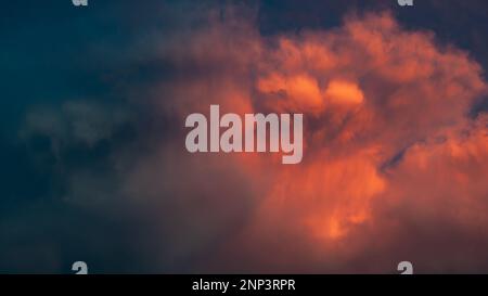 Nuvole drammatiche di rosso, radunandosi prima della tempesta. Il maltempo affascina con la sua potenza e bellezza Foto Stock