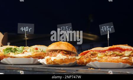 Snack stand presso il mercato agricolo di Praga con un menu in mostra, un hamburger con carne a scatti e pane ripieno di carne e verdure varie. Foto Stock