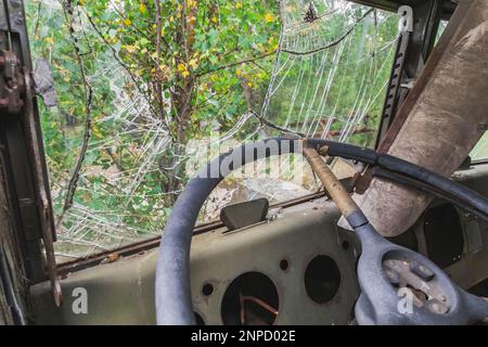 Parabrezza rotto in una vecchia auto abbandonata Foto Stock