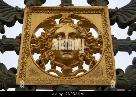 Un volto dorato, un particolare dell'originale recinzione metallica del Palazzo reale, il Palazzo reale di Torino Foto Stock
