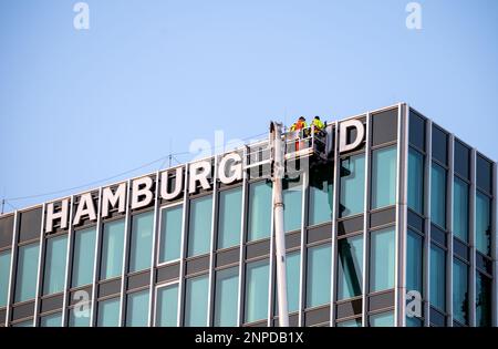Amburgo, Germania. 26th Feb, 2023. La scritta "Hamburg Süd" viene rimossa dall'ex sede della compagnia di navigazione omonima con l'ausilio di un sollevatore telescopico. Dopo circa 60 anni, la scritta viene rimossa dall'edificio e parzialmente sostituita dal nuovo nome dell'edificio. Credit: Daniel Bockwoldt/dpa/Daniel Bockwoldt/dpa/Alamy Live News Foto Stock