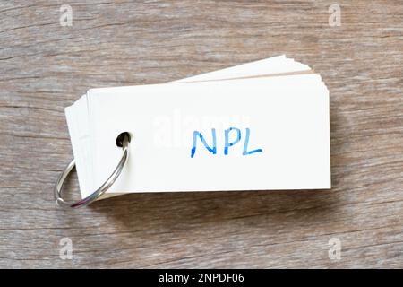 Scheda flash con scrittura a mano in parola NPL (abbreviazione di non Performing Loan, non-Patent Literature) su sfondo di legno Foto Stock