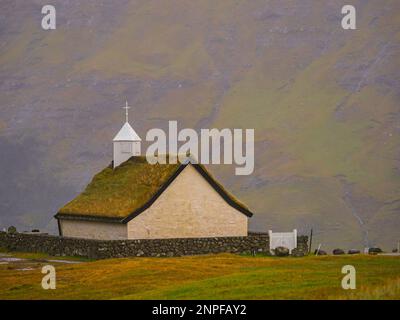 Tipica chiesa in cima a un tappeto erboso nel villaggio di Saksun, Streymoy, Isole Faroe, Danimarca, Nord Europa Foto Stock