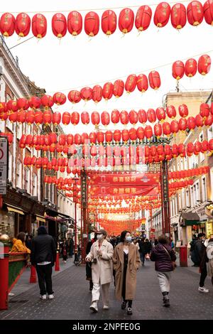 A Chinatown a Londra, fresche lanterne rosse sono appese agli edifici per celebrare il Capodanno cinese. I visitatori vengono a vedere lo spettacolo. Foto Stock