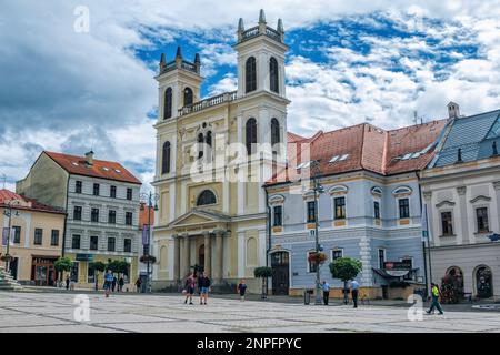 Banska Bystrica, Slovacchia - 15 agosto 2021: Vista di Piazza SNP - edifici storici colorati, la torre della chiesa e le persone che camminano intorno. Foto Stock