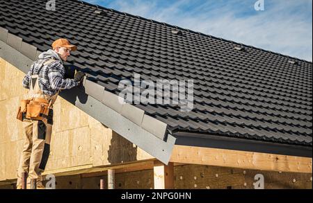 Black Ceramic House piastrelle tetto tema di costruzione. Verifica del tetto dell'appaltatore sul tetto dell'edificio finito. Foto Stock