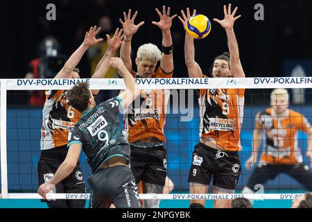 26 febbraio 2023, Baden-Württemberg, Mannheim: Pallavolo, uomini: DVV Cup, SWD-Powervolleys Düren - Berlin volleys, finale, SAP Arena. Marcin Ernastowicz di Düren colpisce contro il blocco di Johannes Tille (l-r), Nehemia Mote e Timothée Carle di Berlino. Foto: Jürgen Kessler/dpa Foto Stock