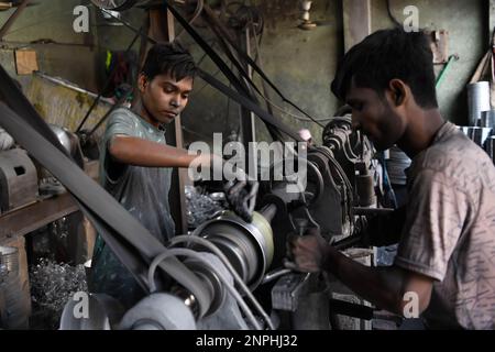 I ragazzi adolescenti sono visti lavorare in una fabbrica di alluminio a Dhaka. Fabbrica di alluminio è molto comune in Bangladesh dove generi differenti di vaso e vaso sono fatti da alluminio. Tale industria crea una solida fonte di occupazione. Tra questi lavoratori molti di loro sono bambini di età inferiore ai 15 anni. Foto Stock