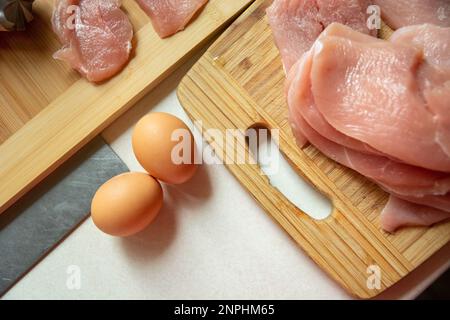 Uova e carne cruda su un tavolo da cucina, vista dall'alto Foto Stock