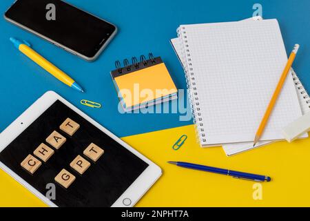 Lavora e studia il background con l'aiuto di un bot chatGPT. Parole in lettere di legno. Vista da tavolo con spazio di copia del notebook aperto. Chat GPT per lavorare e creare. Ucraina, Kiev - 21 febbraio 2023 Foto Stock