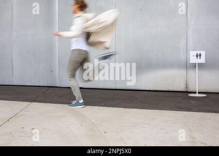 Donna che si precipita in bagno, wc, igiene, bagno. Concetto di urgenza WC. Foto Stock