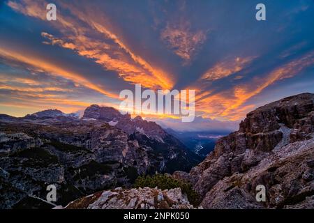 Alba sulle montagne di Zwölferkofel e cima d’Auronzo, la città di Auronzo di Cadore e il lago di Santa Caterina nella valle. Foto Stock