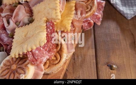 Crescentina. Cibo dell'Emilia Romagna, gnocco fritto o crescentina. Antipasto o aperitivo in Italia. Creshantina con prosciutto crudo, mortadella, salame milanese, capperi, formaggio Foto Stock
