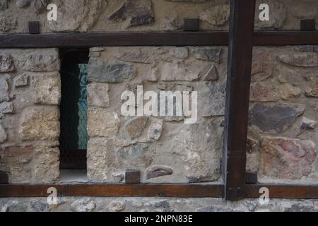 finestre medievali sul muro di pietra. tradizionale architettura dei balcani Foto Stock