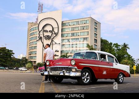 Vettura classica vintage Chevrolet su Piazza della Rivoluzione contro la costruzione di Ministeri dell'informazione e delle comunicazioni con Camilo Cienfuegos ritratto Foto Stock