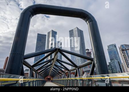 Il nuovo complesso di grattacieli di Deansgate Square incorniciato da un ponte pedonale che attraversa Whitworth Street West a Manchester. Foto Stock