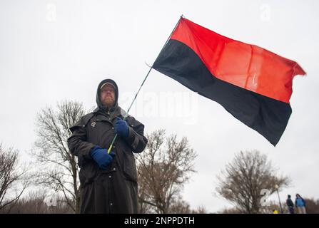 Washington D.C, Washington D.C, USA. 25th Feb, 2023. Un uomo tiene la bandiera rossa e nera dell'Esercito Insurgente Ucraino, un gruppo paramilitare dell'Organizzazione dei nazionalisti Ucraini, a Washington, DC durante un rally sul National Mall per protestare il primo anniversario dell'invasione russa dell'Ucraina il sabato, 25 febbraio 2023. (Credit Image: © Dominic Gwinn/ZUMA Press Wire) SOLO PER USO EDITORIALE! Non per USO commerciale! Foto Stock