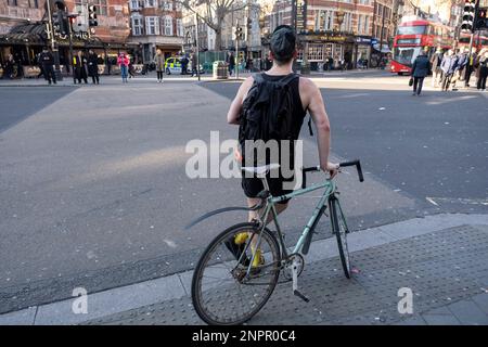 Ciclista in attesa di attraversare la strada aith sua bicicletta a ruota fissa aka fixie il 8th febbraio 2023 a Londra, Regno Unito. Le biciclette a ruote fisse, note anche come fixies, sono un luogo comune soprattutto a Londra, dove sono diventate incredibilmente alla moda. Foto Stock