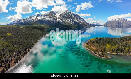 Splendida vista sul lago selvaggio nel Canada settentrionale durante l'estate. Montagne innevate e paesaggi naturali incredibili. Foto Stock