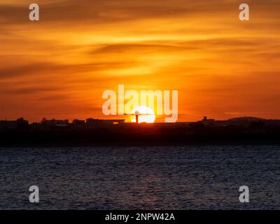 Tramonto dietro la torre di controllo dell'aeroporto di Dublino da Sutton Strand Foto Stock