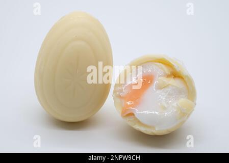 Nuovo uovo di crema al cioccolato bianco che mostra il fondente all'interno Foto Stock