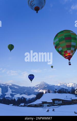 Palloncini sospesi in aria sulle alpi svizzere. Preso al 42nd Festival Internazionale di Balloon a Chateau D'Oex nel gennaio 2023. Foto Stock