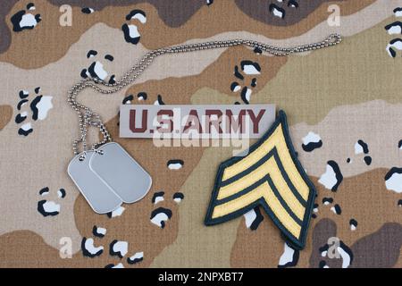 PATCH di rango sergente DELL'ESERCITO DEGLI STATI UNITI e tag cane su sfondo uniforme abito da battaglia del deserto Foto Stock