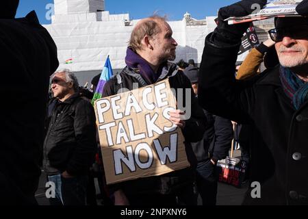 Londra, Regno Unito. 25th Feb, 2023. Un manifestante ha in mano un cartello che recita "colloqui di pace ora” durante la marcia dimostrativa. Dopo il primo anniversario della guerra Russia-Ucraina, i gruppi di protesta si sono riuniti nel centro di Londra e hanno marciato in Piazza Trafalgar, chiedendo la pace in Ucraina e Iran. Credit: SOPA Images Limited/Alamy Live News Foto Stock