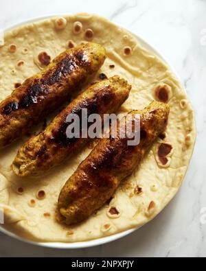 Koobideh Kebab persiano di Chichen. Kebab con curcuma, cipolle, Sumac e altri ingredienti. Su pane di lavash Foto Stock