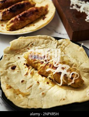 Koobideh Kebab persiano di Chichen. Kebab con curcuma, cipolle, Sumac e altri ingredienti. Su pane di lavash Foto Stock