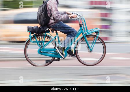 immagine sfocata del movimento di un giovane uomo con una bicicletta in movimento in città Foto Stock