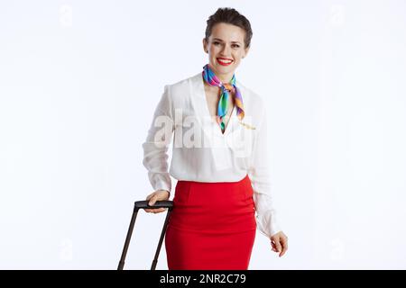 felicemente elegante hostess aria femmina isolato su sfondo bianco in uniforme con borsa trolley. Foto Stock