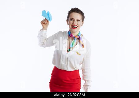 donna felice di classe stewardess su sfondo bianco in uniforme con aereo di carta blu. Foto Stock